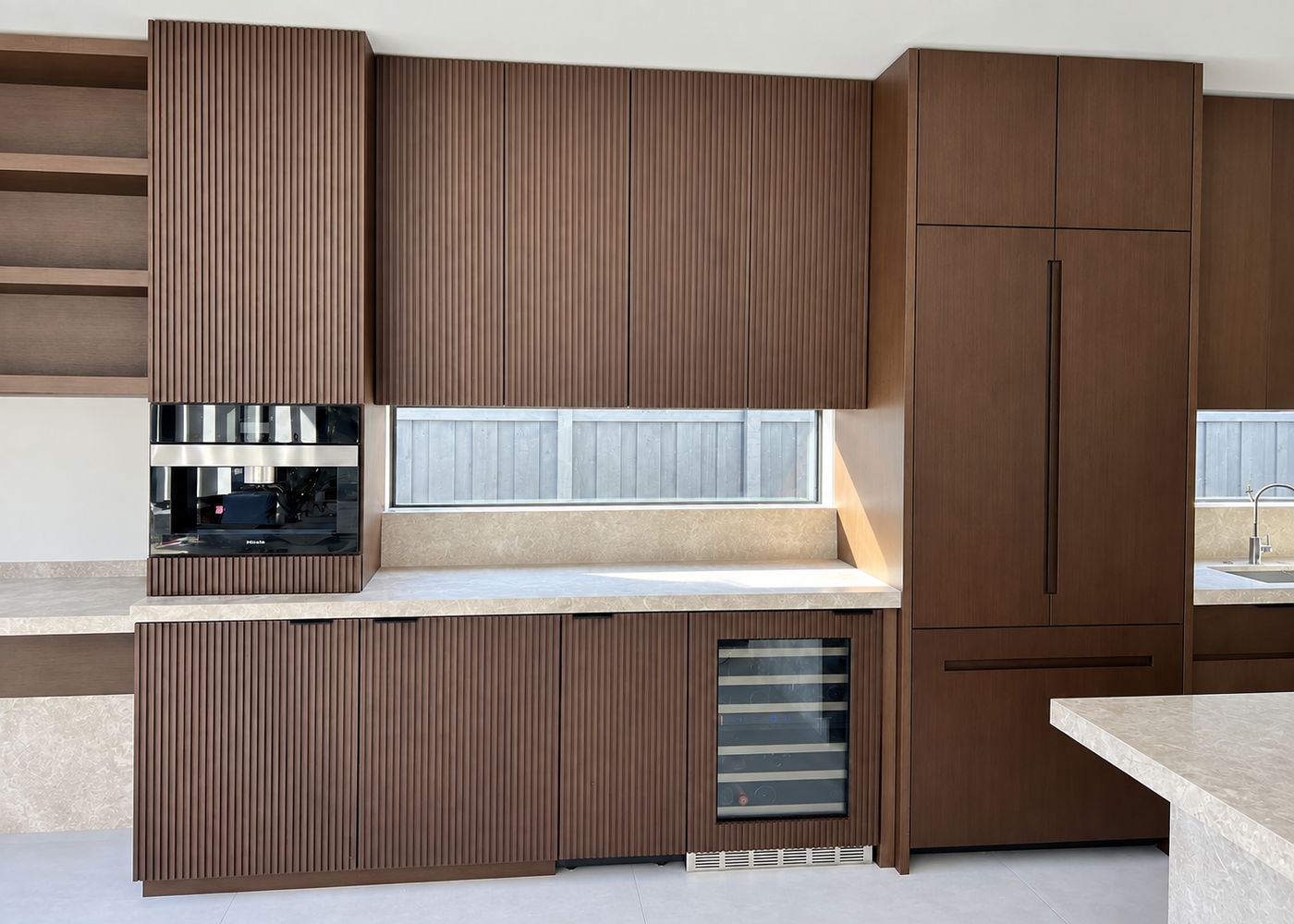 Dark fluted cabinetry with built-in wine fridge, kitchen remodel by MySFContractor