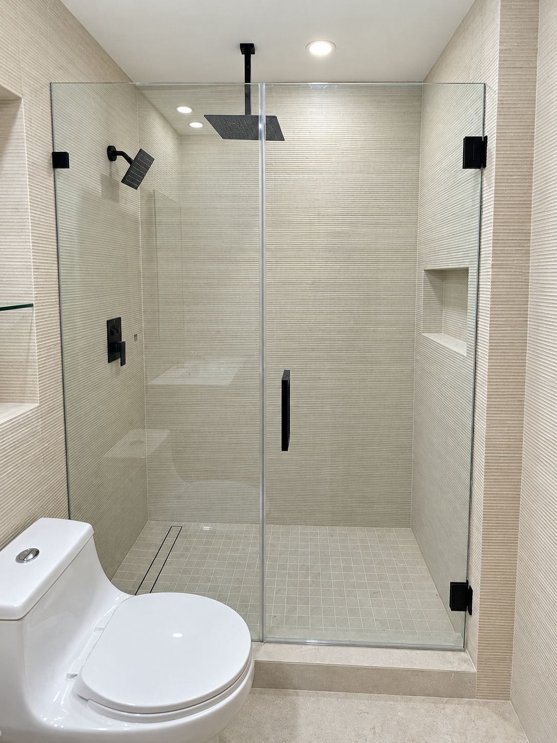Frameless glass shower with black fixtures, bathroom remodel by MySFContractor