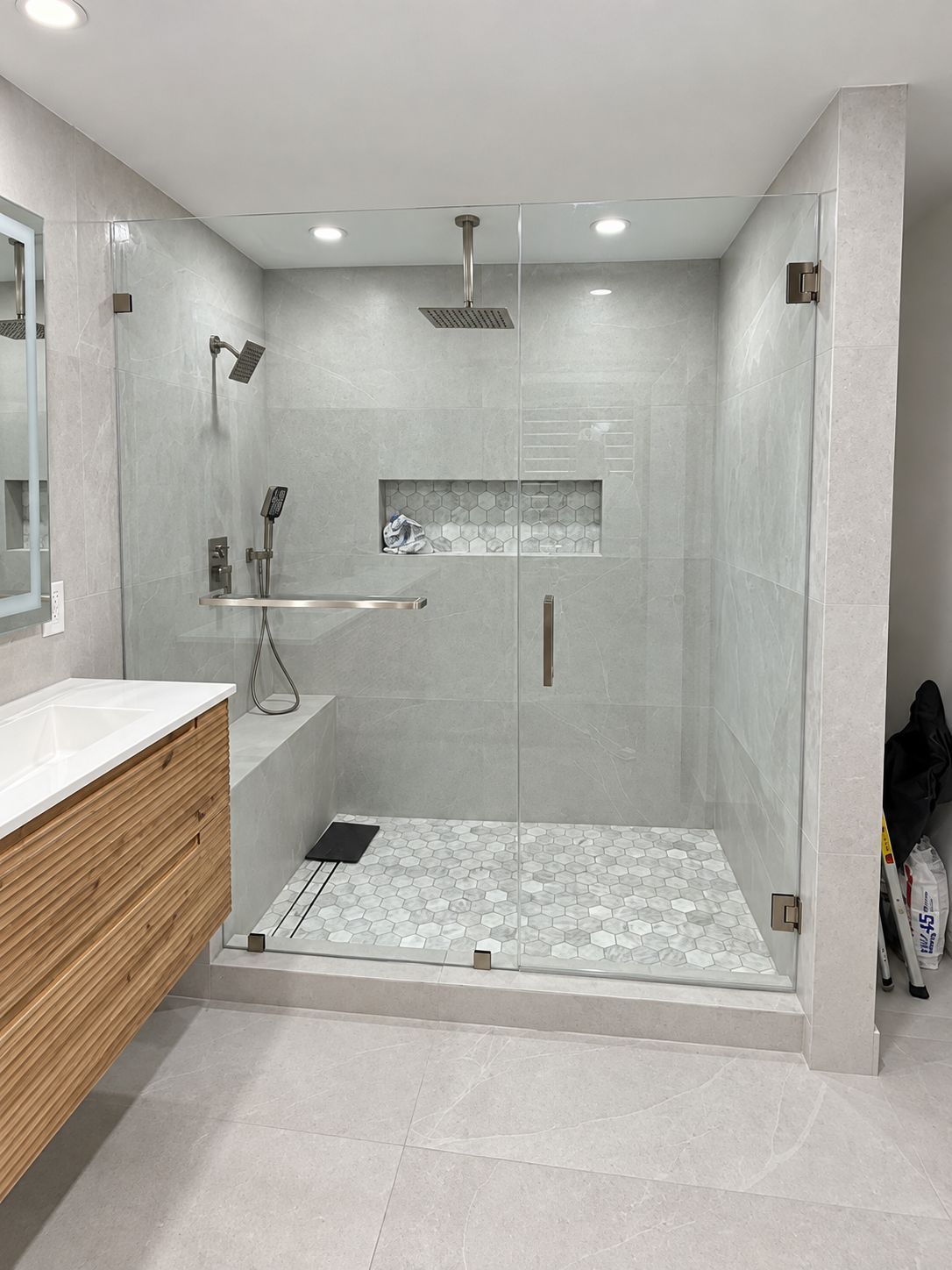 Glass shower with gray stone tile and marble hexagon floor, bathroom remodel by MySFContractor