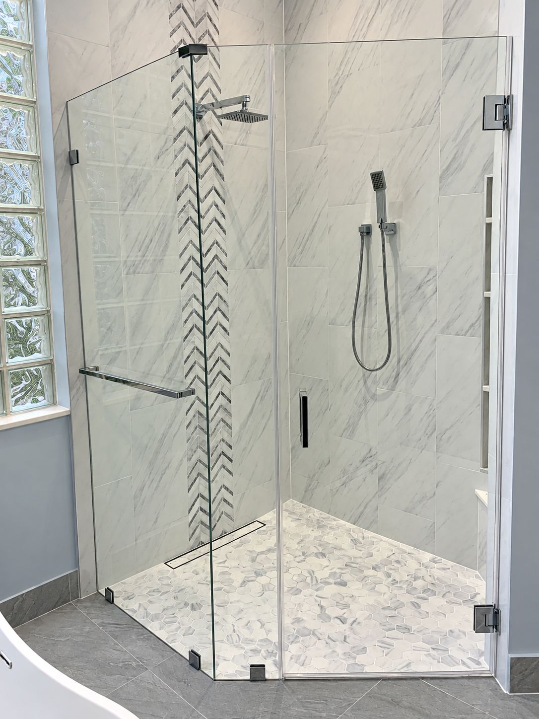 Corner glass shower with marble chevron accent and hexagon floor, bathroom remodel by MySFContractor