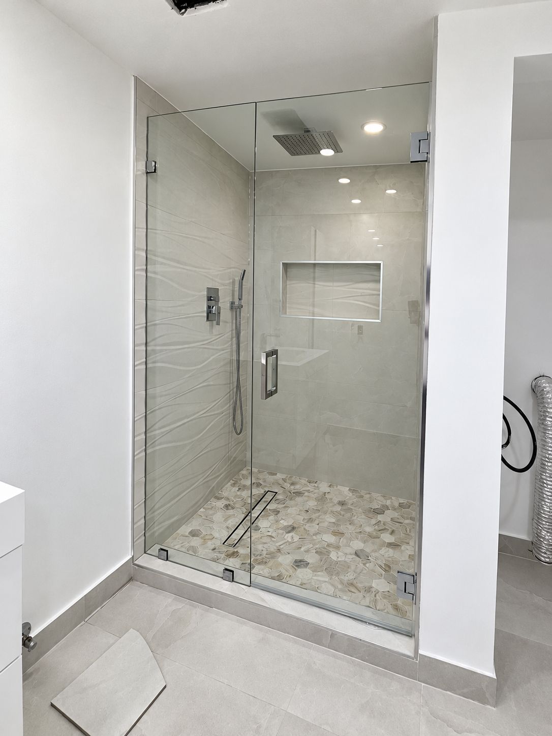 Glass shower with wavy textured tile and hexagon floor, bathroom remodel by MySFContractor