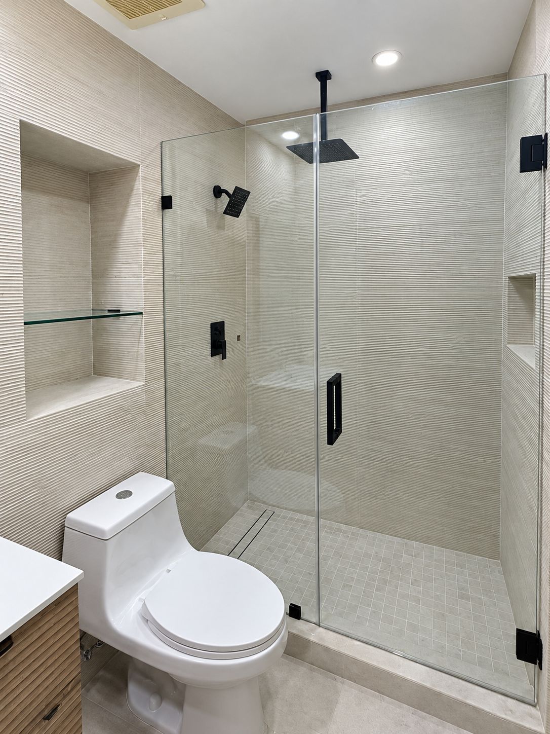 Glass shower with black fixtures and ribbed tile walls, bathroom remodel by MySFContractor