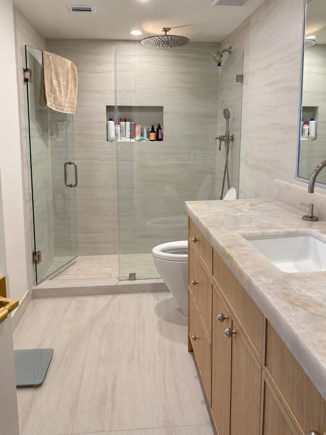 Bathroom remodel with frameless glass walk-in shower, rain showerhead, recessed niche and white oak vanity with marble top by MySFContractor